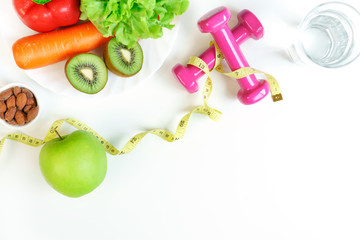 Healthy food clean eating selection with fruits, vegetables, dumbbell ,tape measure, a glass of water almond on white table background. Selection of healthy food concept. Organic food, diet concept