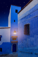 Arabian Night. Oriental tales. Magical night street in the blue city. Medina of Chefchaouen town, Morocco. Dreamy and romantic background. Luminous lantern in the dark. One thousand and one nights