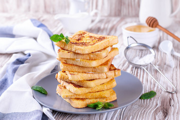 Fresh homemade crispy toast with honey on white wooden table