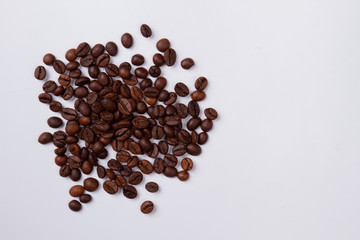 Top view pile of fresh roasted coffee beans isolated on white. Scattered brown grains.