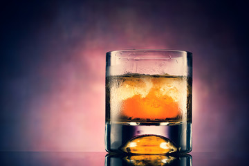 Glass of whiskey with ice cubes