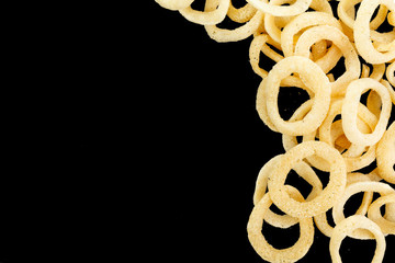 Snack onion ring  isolated over black background. Pile of crispy onion rings close-up as background
