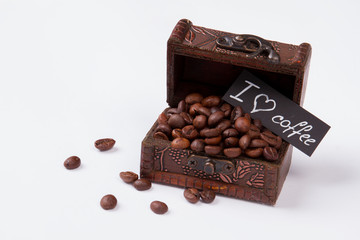 Wooden treasure chest full of roasted coffee beans. Love for coffee concept. Coffee treasury isolated on white.