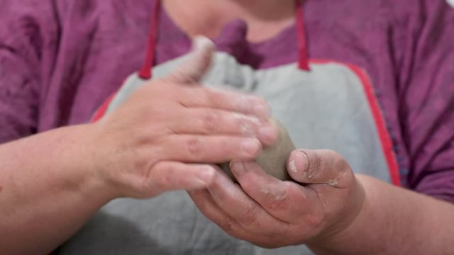 Hände formen eine Kugel aus Ton