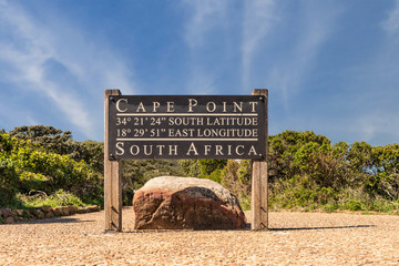 Obraz premium Cape Point sign with coordinates next to the lighthouse path with stunning clouds