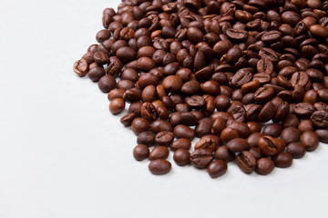 Close up big pile of roasted coffee beans. Isolated on white background.