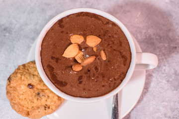 Cramped chocolate with nuts and cookies close-up. Tasty drink.