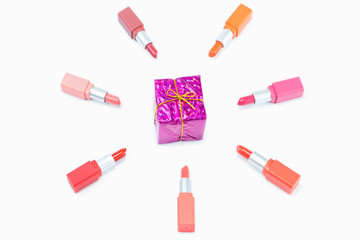 colorful pastel lipstick arranged in a circle and pink gift box