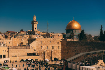 Jerusalem western wall. Cityscape image of Jerusalem. View of prayers, wishes and prays. Dome of the Rock in Jerusalem old city, Israel. Blue sky. View from the Temple Mount.