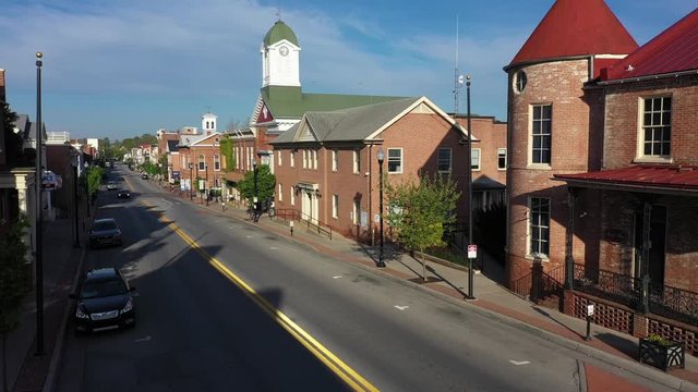 Aerial ascent in the middle of main street in Charles Town, West Virginia on a spring morning with the courthouse in the distance.