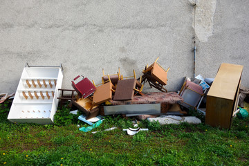 Discarded household waste after the reconstruction of the room by the building on the grass