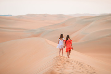 Fototapeta na wymiar Girls among dunes in Rub al-Khali desert in United Arab Emirates