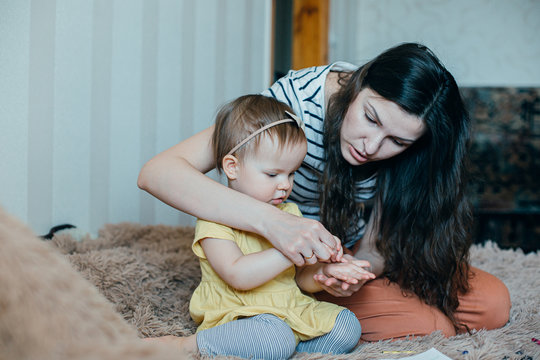 Calm mother playing finger games with her toddler child stock photo