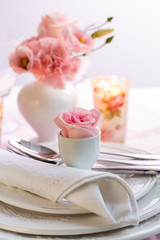 Place setting with beautiful bouquet in pink and white on the kitchen table