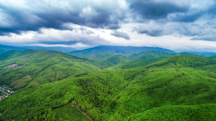 Spring landscape in mountains and the dark blue sky with clouds. A drone shot.