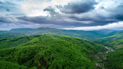 Fototapeta na wymiar Spring landscape in mountains and the dark blue sky with clouds. A drone shot.