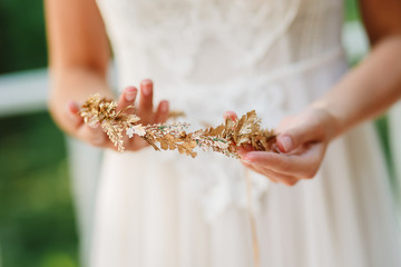 Bride is holding a diadem. Beautiful light, blurred background.