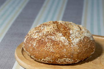 Freshly baked, homemade seeded brown bread on a wooden board
