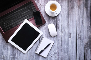 Top view of digital tablet, laptop and notepad on table 