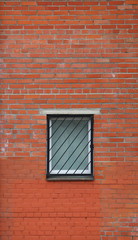 Barred window in the red brick wall