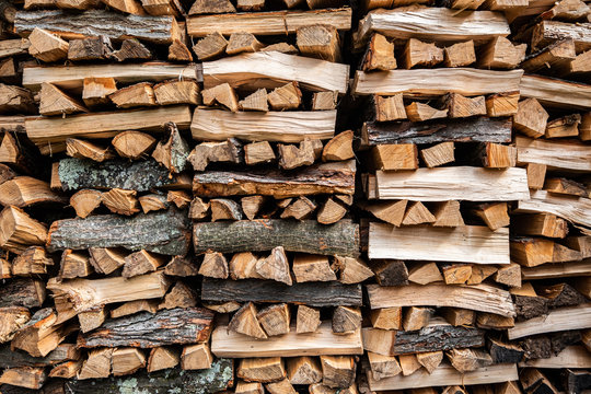 Stack of split firewood seasoning outside for sustainable energy through the winter for use in the wood stove
