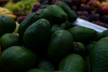 Green avocado on a store counter.