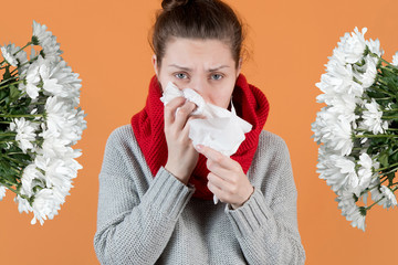 The girl is allergic and has flowers on both sides. Flower allergy. Orange background