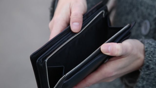 Female hands holding empty purse. oung woman shows her empty wallet. Bankruptcy. The concept of poverty. Poverty business concept. An empty wallet in the hands of women. The concept of poverty.