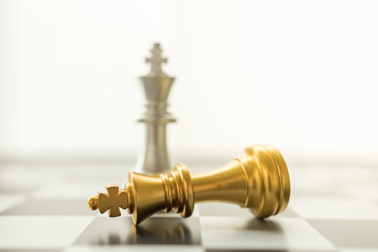 Sport board game, Business and planning concept. Closeup of falling gold and silver King chess piece on chessboard with copy space.