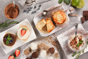 Desserts, proper nutrition. Apple pie, candy, brownie, cheesecake, chocolate mousse with fresh blueberries, strawberries, chocolate and mint on a light background. Flatlay6 top view. Background image