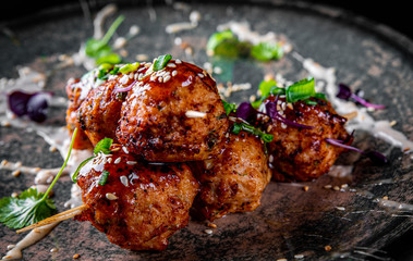 deep fried meatballs in plate on black wooden table background
