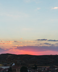 Atardecer rojo y nublado con pueblo antiguo de España