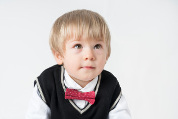 Little boy looking up on gray background 