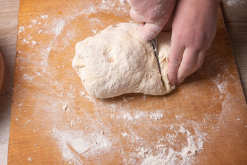 Female hands mixing dough in the home kitchen.