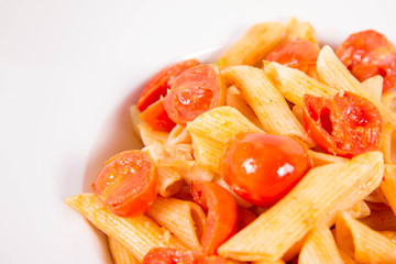Penne with tomatoes, garlic and mozzarella on a white background
