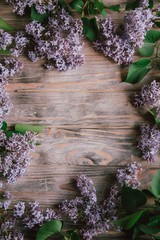 The beautiful lilac flowers on a wooden background