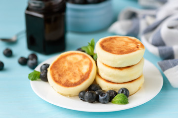 Portion of cottage cheese fritters served with fresh blueberries. Tasty breakfast food. Russian and ukrainian cuisine Syrniki
