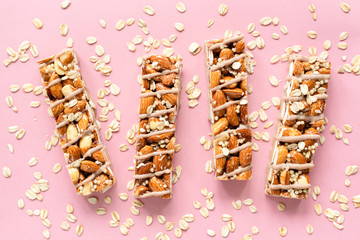 Almond and oat granola protein bars on pink background, top view. Healthy vegan granola bars