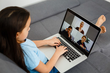 Cute little girl using laptop at home. Education, online study, home studying, distance learning, schoolgirl children lifestyle concept