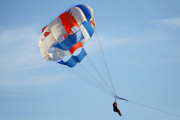     Parasailing. Parachute with passengers against the blue sky. The concept of the popular extreme - entertainment.