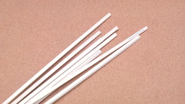 Set of wooden sticks being tossed over a cork surface