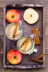 Warm soothing tea made from apples and cinnamon in glasses on a wooden table. Detox concept, antidepressant. Rustic style. Top view