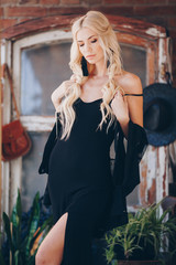 Obraz premium Portrait of beautiful young blonde in the black clothing of style of бохо in a summer arbour