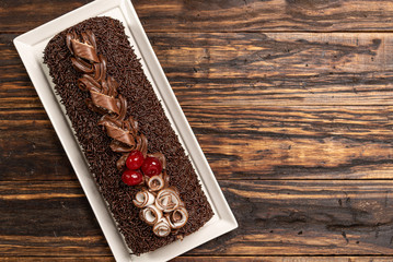 A delicious Swiss roll on woodden background. Sponge roll cake. Brazilian dessert. Rocambole cake