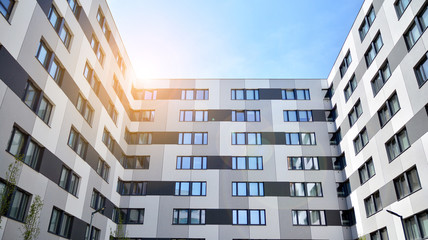 Modern apartment buildings on a sunny day with a blue sky. Facade of a modern apartment building. Glass surface with sunlight.