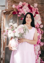 Portrait of beautiful brunette woman in pink dress with pink and white pi-mesons