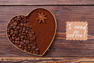 Whole and instant coffee arragedn in a shape of heart. One with one part filled with coffee beans and another one with instant coffee. I need coffee.