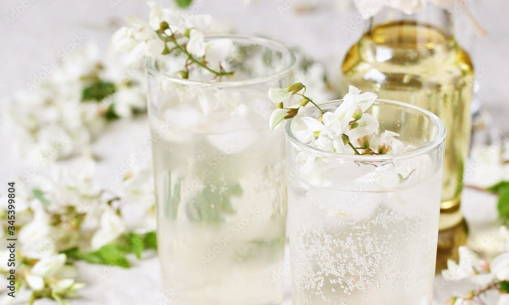 Poster acacia flowers drink. lemonade with a syrup of white acacia flowers. Edible flowers.