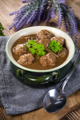 Pork meatballs with noodles in a green bowl.