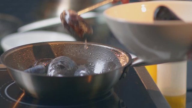 Traditional italian seafood pasta with clams Spaghetti alle Vongole
Chef toassing mussel pan 
Hissing mussels in frying pan
Steamed Seafood in a pan
close-up shot 4.6K